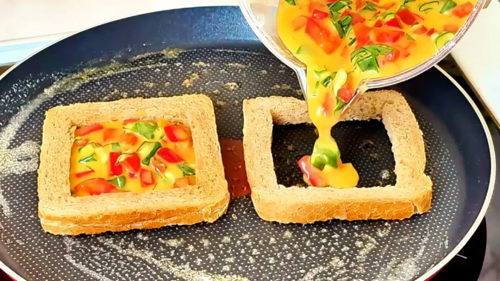Crispy breakfast toast filled with eggs, vegetables, and cheese in a frying pan