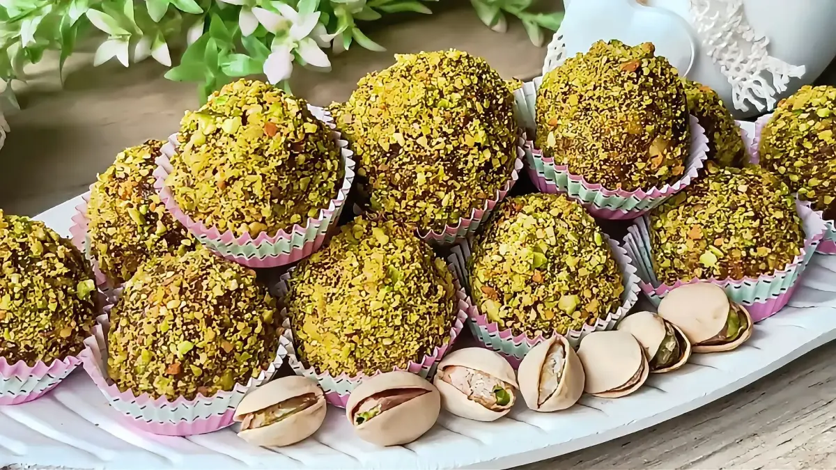No-bake Pistachio Date Balls coated in crushed pistachios served in colorful paper cups