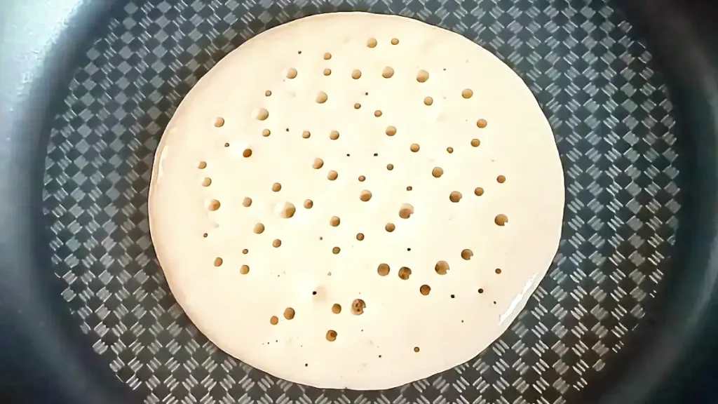 Fluffy Pancake in a pan with bubbles forming