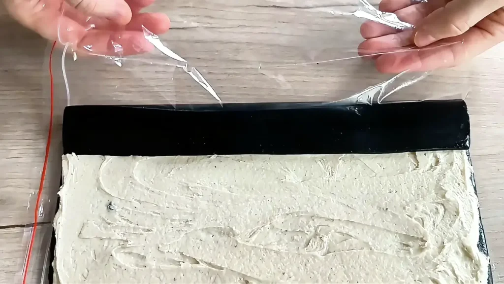 Rolling the Oreo dough filled with cream into a log shape