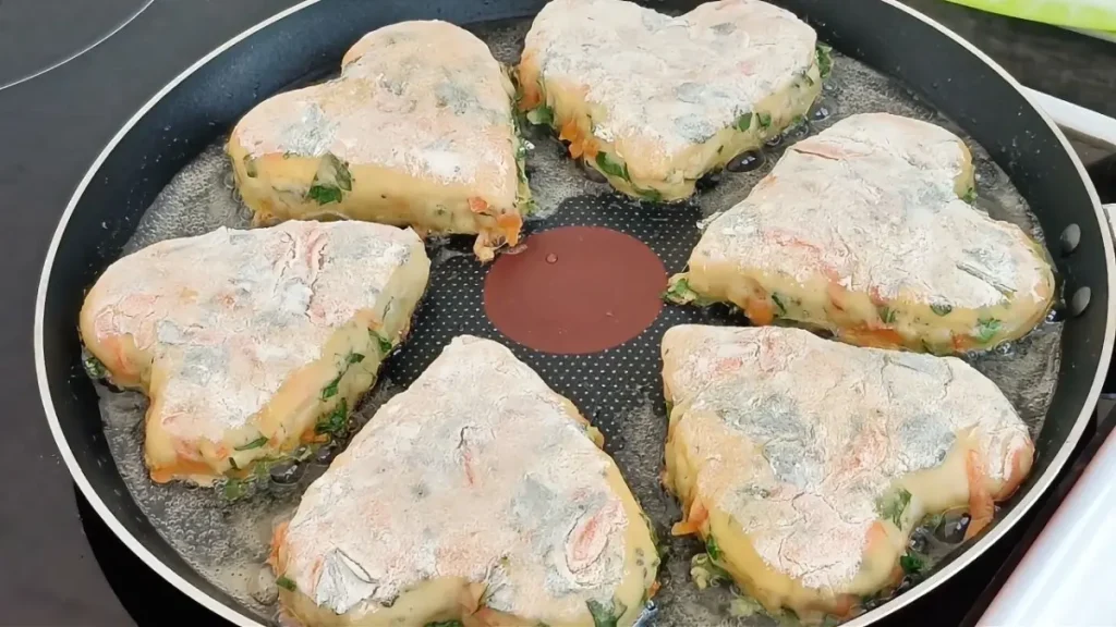 Skillet cooking savory zucchini and cheese buns on low heat